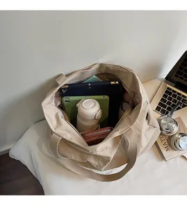 Interior view showing the large capacity of the beige tote bag with daily essentials
