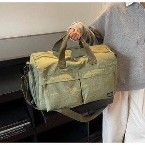 Close-up of olive green travel bag showing nylon texture and functional pockets