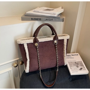 Detail of winter brown suede tote bag with white faux shearling trim and chain strap