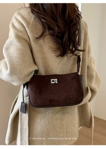 Brown suede shoulder bag with silver turn-lock clasp shown on a beige wool coat