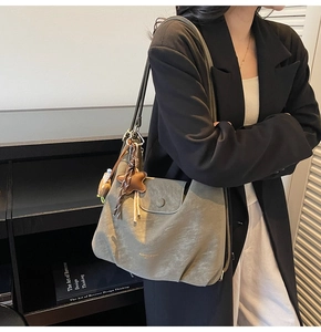 Détail d'un grand sac cabas vert sauge en similicuir avec pendentif étoile et texture