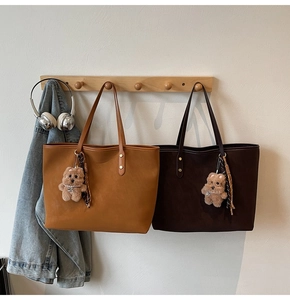 Detailansicht der Vintage-Tote-Bags in Braun und Kaffee mit süßen Bärchen-Anhängern