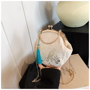Detail of embroidered bird and floral pattern on a retro chain shell bag with tassel
