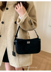 Detail view of the black retro shoulder bag featuring a silver rotating lock and matte texture