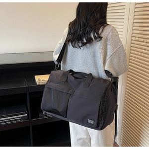 Close-up of black nylon travel bag with multi-pockets and adjustable shoulder strap