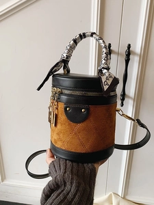 Brown suede cylinder bucket bag with quilted stitching and heart silk scarf handle decoration