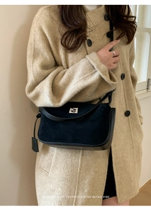 Detail of black suede and leather shoulder bag with silver metal twist lock closure