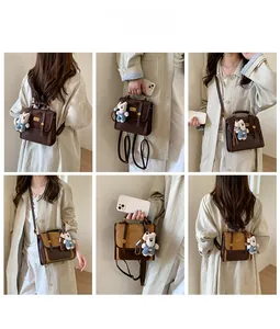 Detail view of retro mini backpack in brown PU leather featuring a cute bear plush charm