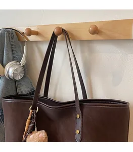 Detailansicht der braunen Tragetasche aus Kunstleder mit Plüschkatze und Metallnieten