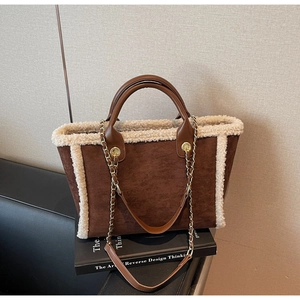 Detail of winter brown suede tote bag with cream fleece trim and chain strap accent