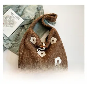 Detail of plush floral tote bag showing brown sherpa fabric and horn button closure