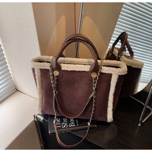 Detail of winter suede tote bag with faux fur trim and gold chain shoulder strap