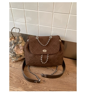 Detailed view of brown quilted bucket bag with silver twist lock and chain strap