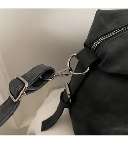 Detailed macro of high-gloss gunmetal hardware and matte black material on tote bag