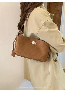 Brown suede underarm bag with silver twist lock shown on a model in retro style