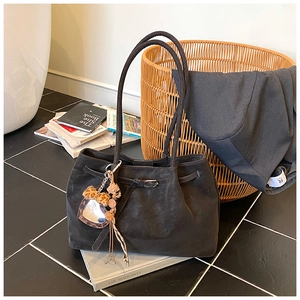 Detailaufnahme der schwarzen Wildleder-Tote Bag mit Leoparden-Herzanhänger
