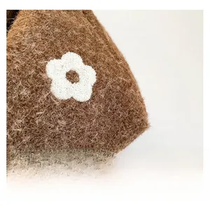 Detailed close-up of brown plush tote bag featuring soft texture and white flower embroidery
