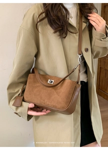 Detail of retro brown leather crossbody bag with silver metal twist lock and slim strap