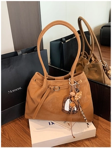 Detailansicht der braunen Wildledertasche mit Leoparden-Herzanhänger und Fransen