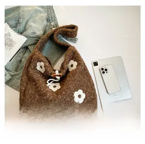 Detail of plush brown tote with floral embroidery, wooden buckle, and spacious interior