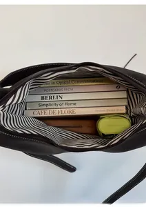 Detail view of the large capacity dark brown bucket bag interior with striped lining