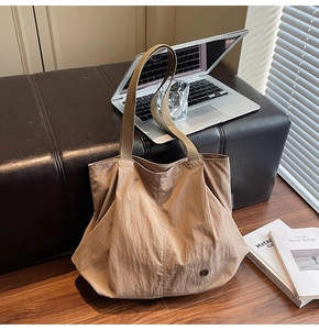 Close-up of khaki nylon tote bag with textured fabric and stylish side label detail