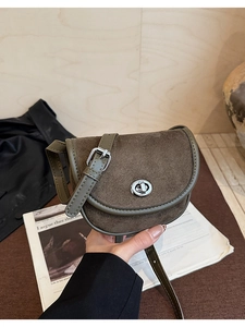 Detail of vintage saddle bag featuring olive green leather and brown suede textures