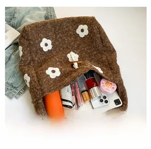 Macro shot showing large storage capacity of brown plush tote bag with floral embroidery