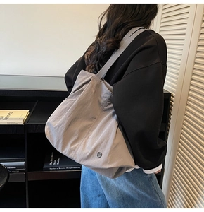 Gray large capacity tote bag worn by model showing casual minimalist commuter style