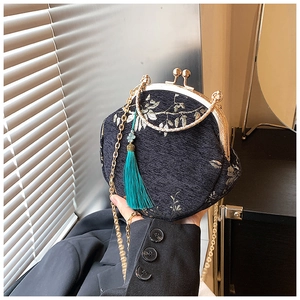 Detailed view of the exquisite floral embroidery and silk tassel on the vintage shell bag