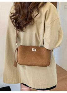 Minimalist retro dark brown suede shoulder bag worn with a beige trench coat