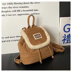 Detailed close-up of brown faux leather mini backpack with white fleece trim and bear tag