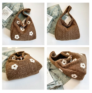 Detail of brown plush tote bag with white floral embroidery and toggle closure