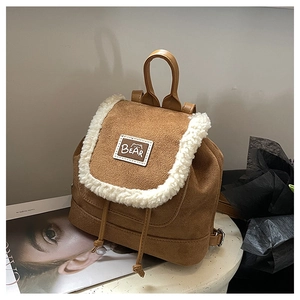 Detailed close-up of dark camel suede mini backpack with faux shearling fleece trim and logo