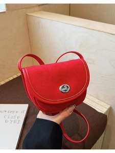 Detailed view of red frosted leather saddle bag with silver metal twist lock closure