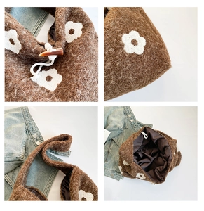 Detail view of brown plush tote bag with white flower embroidery and toggle closure