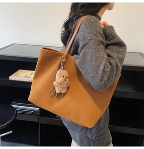 Tragetasche aus karamellfarbenem Kunstleder mit Teddybär-Anhänger und Perlenkette