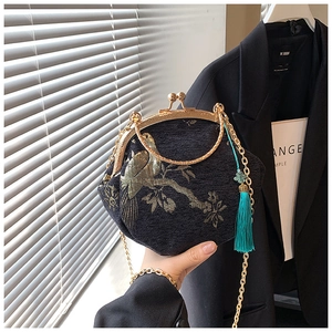 Detail of Chinese style shell bag with gold bird embroidery and metal handle chain