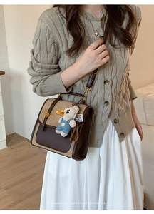 Detail of retro faux leather backpack with suede panel and cute white bear charm