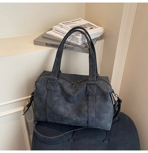 Close-up of retro dark gray boston handbag with leather texture and adjustable strap
