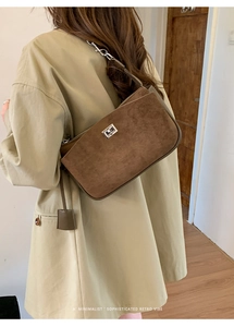 Brown suede minimalist shoulder bag with silver turn-lock clasp shown on coat model