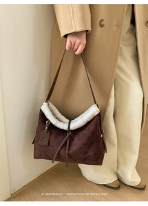 Detail of dark brown suede tote bag with white faux fur trim and leather shoulder strap