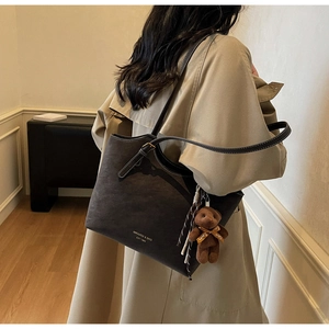 Détail du grand sac cabas en daim marron avec pendentif ours et lettrage doré