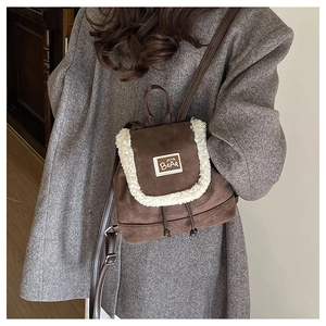 Detail of winter vintage brown suede backpack with plush fleece trim on model