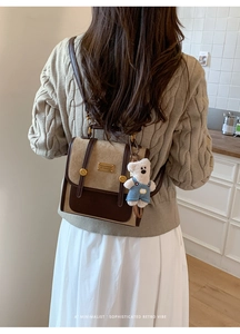Detail view of a retro patchwork backpack with a cute teddy bear charm on side