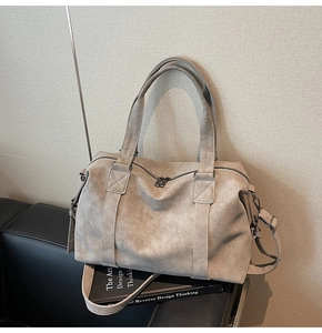 Macro detail of high-capacity matte tote bag with reinforced handles and long strap