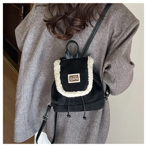 Detail of plush lamb wool trim and brown bear leather patch on black winter backpack