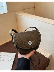 Detail of vintage saddle bag featuring matte suede texture and silver twist lock closure