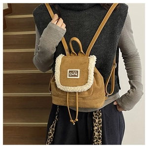 Detail view of brown fleece backpack with white faux shearling trim and BEAR logo patch