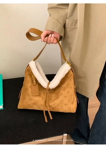 Close-up of vintage brown suede tote with faux fur trim and embossed monogram pattern